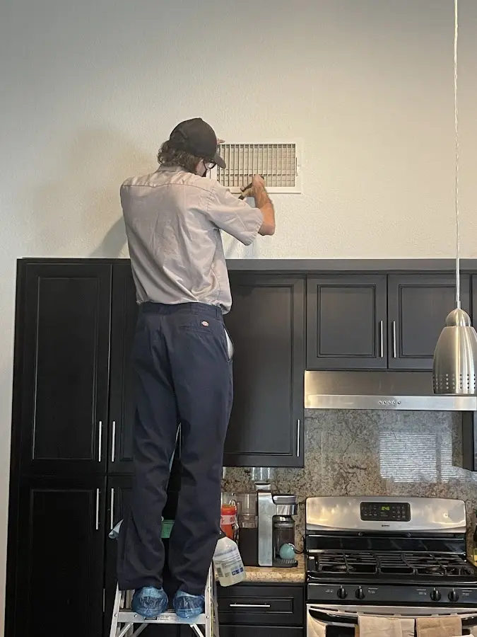 Technician inspecting an air vent during HVAC service in Deltona